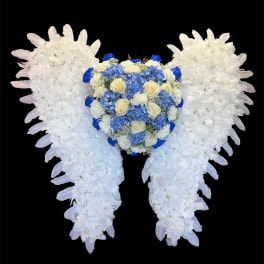 Heart-shaped floral tribute with white wings and blue roses