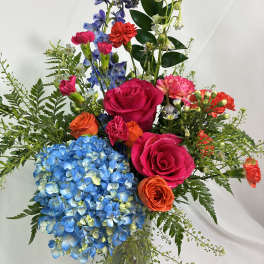 Colorful mixed bouquet in a clear glass vase with roses and hydrangea