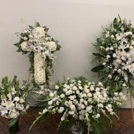 Four white floral funeral arrangements with lilies and roses