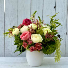 Mixed pink and white flower arrangement in a white vase