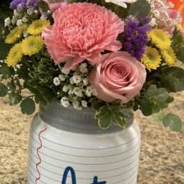 Mixed bouquet in a notebook-style vase with pink and white flowers