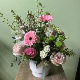 Pink gerbera daisies and roses in a white vase