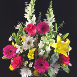 Colorful mixed flower basket with roses, gerbera daisies, lilies, and snapdragons