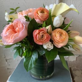 Pink and peach flowers arranged in a glass vase