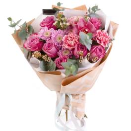 Pink rose bouquet with orchids and carnations wrapped in paper