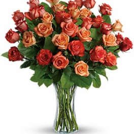 Bouquet of orange and red roses in a clear glass vase