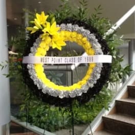 Large floral wreath with yellow flowers and a white ribbon reading West Point Class of 1969