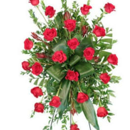Standing spray of red roses with greenery on a metal easel