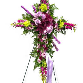 Floral standing cross with purple and pink flowers on an easel