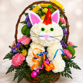 Basket arrangement shaped like a cat with colorful flowers and ribbons