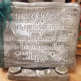 Decorative memorial sign with a ribbon bow and engraved quote