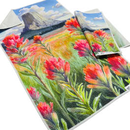 Two printed towels with a colorful flower and mountain design