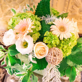 Bouquet of pale peach flowers and green hydrangeas with decorative accents