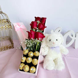 Red roses in a gift box with chocolates and a white teddy bear