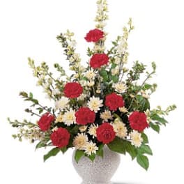 Red and white flowers arranged in a speckled vase