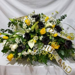 Large floral spray with black and yellow roses and white lilies