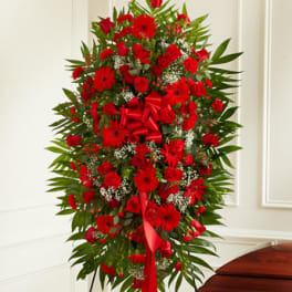 Tall red floral standing spray with a red ribbon bow
