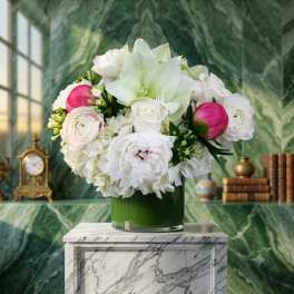 White and pink floral arrangement in a green glass vase