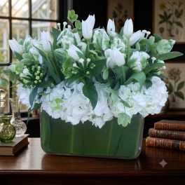White tulips and hydrangeas arranged in a rectangular vase