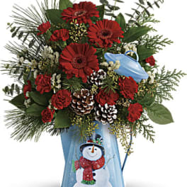 Red gerbera daisies and carnations in a blue snowman vase
