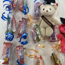 Graduation teddy bear with wrapped candy bars and curled ribbons