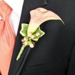 Calla lily boutonniere with pink ribbon on a black suit lapel