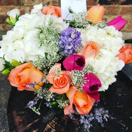Bouquet of white hydrangeas with orange, pink, and purple flowers