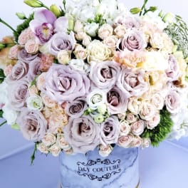 Large pastel bouquet in a marble-print hatbox with roses and orchids