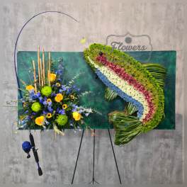 Large floral display with blue, yellow, and green flowers on an easel.