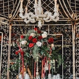 Red and white rose centerpiece on a formal table beneath a chandelier