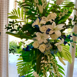 Tall white floral standing arrangement with lilies and roses