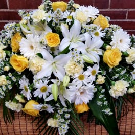 Yellow roses and white lilies with daisies in a low arrangement