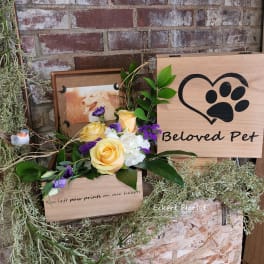 Yellow and purple rose arrangement beside a wooden pet memorial sign