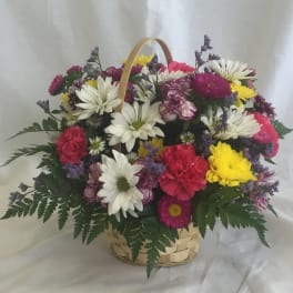 Mixed bouquet of daisies, carnations, and chrysanthemums in a basket