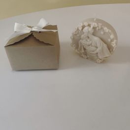 A small kraft gift box with a white ribbon beside a white decorative figurine.