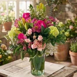 Mixed pink and green floral arrangement in a glass vase