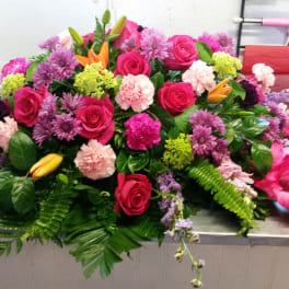 Large mixed floral arrangement with pink roses and purple blooms