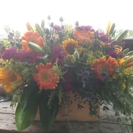Large mixed bouquet of orange and pink flowers in a box