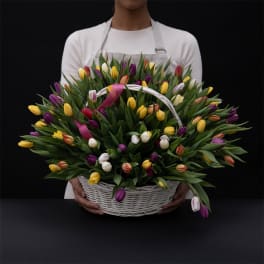 Basket of multicolored tulips held by a person