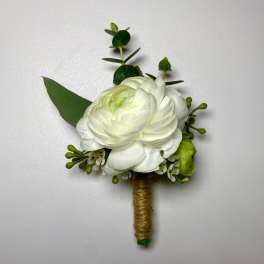 White floral boutonniere with green accents and wrapped stem