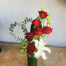 Red roses and white lilies in a tall green vase