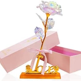 Decorative artificial flower on a gold "love" stand with pink gift boxes