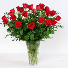 Red roses arranged in a clear glass vase