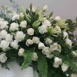 Large white floral spray with lilies, roses, and carnations