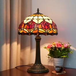 Table lamp beside a small potted bouquet of pink flowers