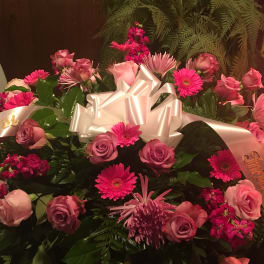 Pink and lavender flower arrangement with a white ribbon bow