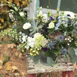 Mixed bouquet in a metal container with white, blue, and green flowers