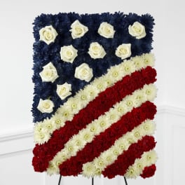 Standing floral spray shaped like an American flag with red, white, and blue flowers