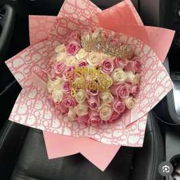 Pink and cream rose bouquet wrapped in patterned pink paper