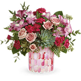 Pink and blush floral arrangement in a patterned glass vase